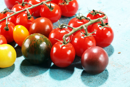 桌上有五颜六色的有机西红柿。新鲜有机红黄色橙和绿色西红柿