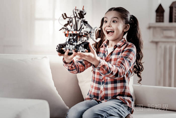 可爱的小女孩惊奇在机器人