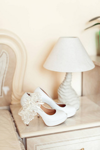 白色婚礼鞋用一盏台灯在基座上的高跟鞋。所有在明亮的颜色