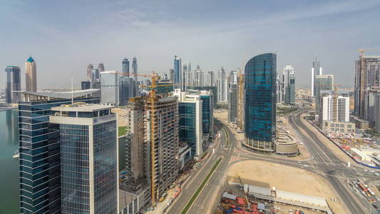 迪拜商业海湾塔在天时间空中 timelapse。一些摩天大楼和在建的新塔楼的屋顶视图。天空中的云彩