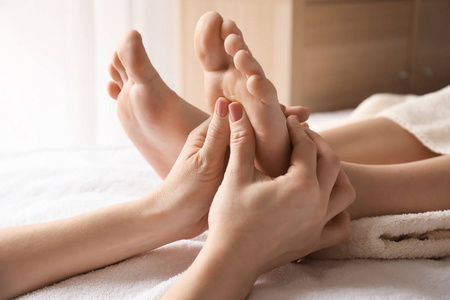 在水疗沙龙接受足疗的美丽少妇照片