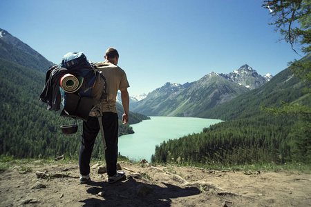 人旅行者与大背包登山旅行生活方式概念湖和山在背景夏天极端假期室外。阿尔泰山。kucherlinskoe 湖西伯利亚。俄罗斯
