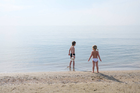 两个孩子在夏天时间在沙滩上玩