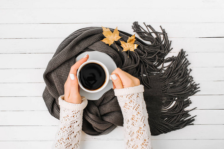 女人的手拿着一杯咖啡裹在木质的围巾上。秋季或冬季的概念。平躺, 顶部视图