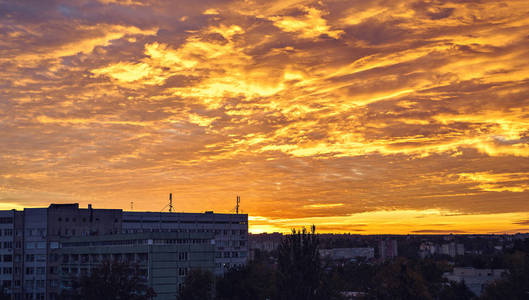红色日落与云彩在秋天季节在城市之上。背景蓝天。负拷贝空间, 文本位置。摩尔多瓦基希讷乌