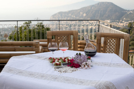 阳台上的桌上准备的浪漫晚餐俯瞰那不勒斯海湾和维苏威