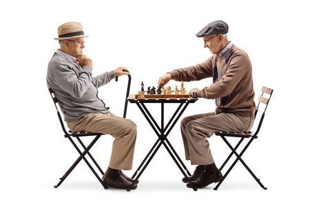 老年人在白色背景下玩象棋游戏