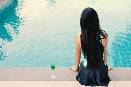 漂亮的女人在游泳池玩放松假日的时间