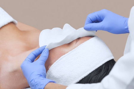 海藻护肤美容师的清洁和滋润皮肤的程序, 应用一个褐藻面具的脸上的