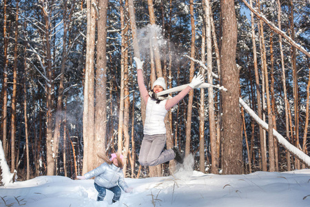 年轻的母亲和女儿在雪地里玩得开心。