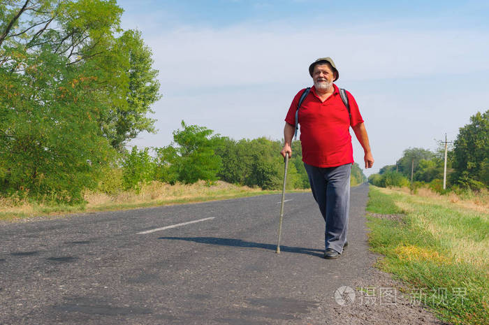 夏季, 在乌克兰农村地区, 快乐的高级徒步旅行者走在路边