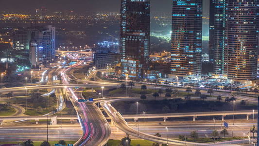 在一个大城市的夜晚 timelapse 的道路交叉路口的鸟瞰图。阿联酋迪拜滨海区城市景观与汽车和摩天大楼