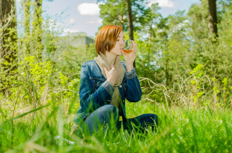 孤独的女孩享受一杯绿茶在森林里