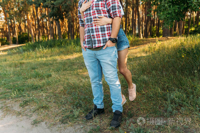 一个穿着格子衬衣和牛仔裤的家伙, 手臂上有一块手表, 一个穿白色上衣