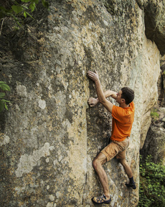 一手抓攀岩者伸手去拿他下一手持有约书亚树民族照片