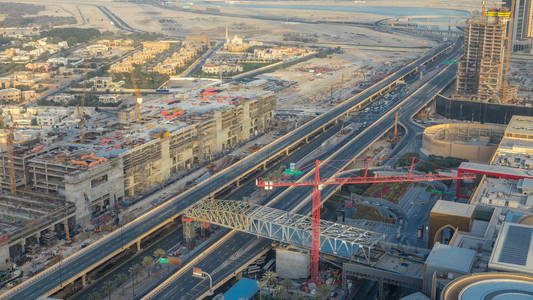 迪拜市中心的日落 timelapse 与购物中心, 建筑工地和交通的道路上。上方视图