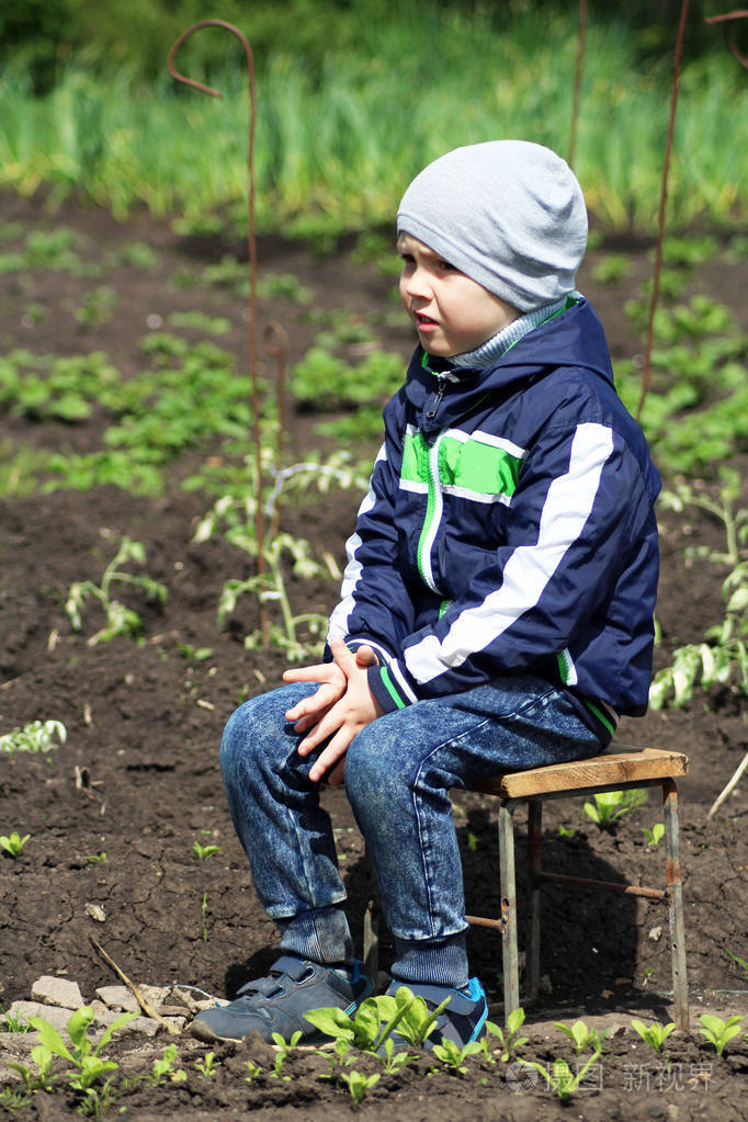 小男孩坐在花园的椅子上, 悲伤, 户外