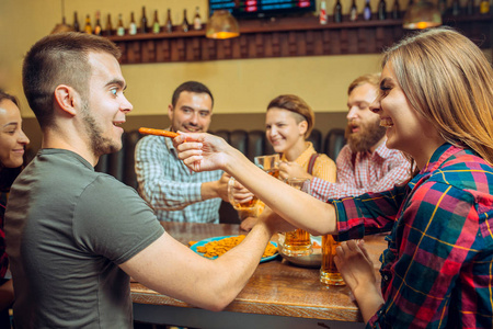 人 休闲 友谊和沟通的概念   快乐的朋友喝啤酒，说话和无比眼镜在酒吧或酒馆