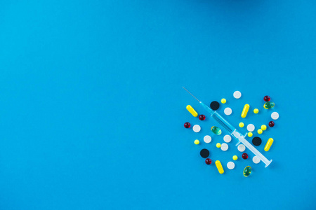 彩色药丸和胶囊在蓝色背景.药剂主题, 胶囊丸与药物抗生素包装照片