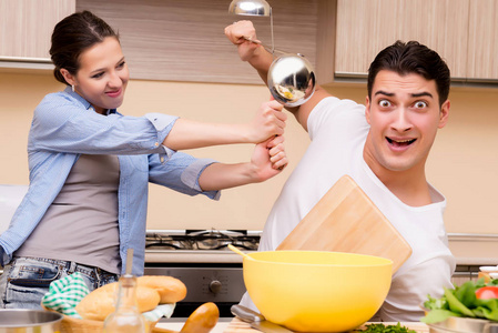 年轻的家庭做有趣战斗在厨房