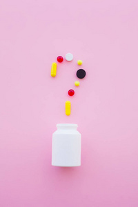 医学概念。彩色药丸和胶囊在粉红色的背景。药剂主题, 胶囊丸与药物抗生素包装