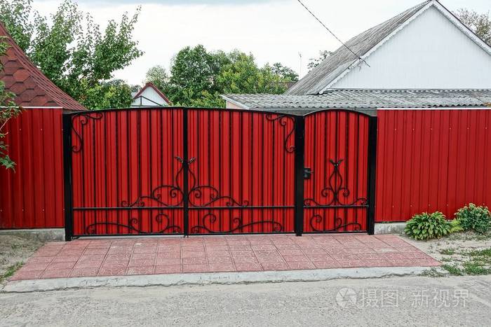封闭的红色大门和街道上的金属栅栏