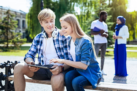 轻松的大学同学在户外聊天和微笑照片
