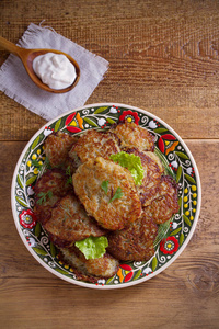 薯饼, latkes, draniki, 土豆饼。盘子里的蔬菜煎饼, 木桌。垂直高开销