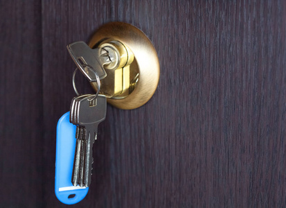 木门特写中钥匙孔的一个新键照片