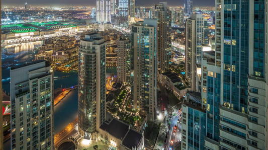 迪拜市中心夜 timelapse, 照亮了奢华的现代建筑和喷泉, 阿拉伯联合酋长国未来的城市风貌。摩天大楼的空中俯视图