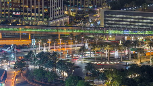 迪拜市中心夜 timelapse, 照亮了豪华现代建筑和喷泉与交通在圈子, 未来的城市风貌阿拉伯联合酋长国。摩天大楼的空中俯视图