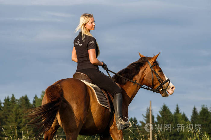 穿着运动服装的年轻女子在马场享受骑马