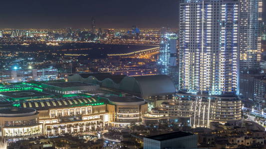 迪拜市中心夜 timelapse, 照亮了奢华的现代建筑和购物中心, 阿拉伯联合酋长国未来的城市风貌。摩天大楼的空中俯视图