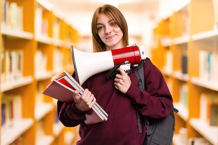 学生妇女拿着扩音器在不专心的背景下