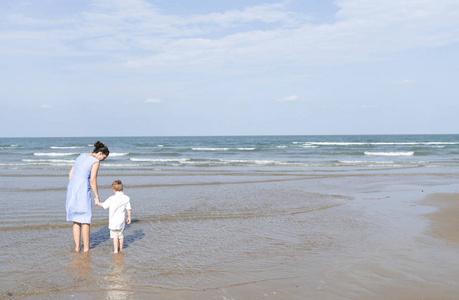 母亲和小儿子的后景色在沙滩上不寒而栗