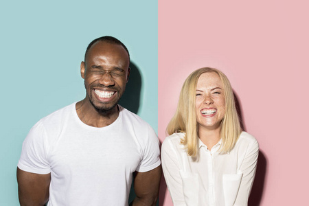 快乐的非洲男人和女人。粉红色演播室白种女性和黑人男性模特的动态图像