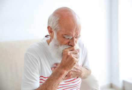 可怜老人咳嗽老人坐在沙发上照片