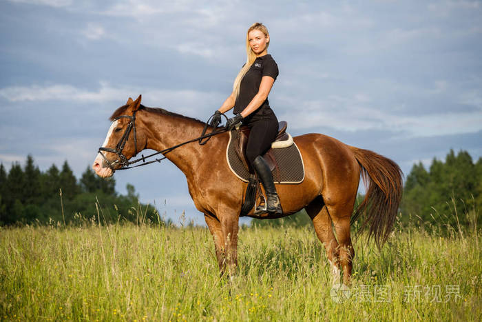 户外拍摄的美女金发女郎白天骑马.