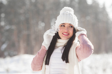 在冬天抱着雪花的年轻迷人的女人特写画像