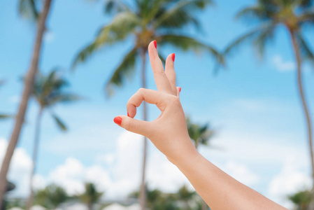度假, 海滩休息。在夏季海滩的背景下, 女子手展示好手势手势