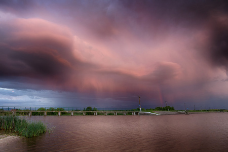 红色的天空。在湖。彩虹。雨后的夕阳红。低调 黑暗的背景 现场照明和丰富的老船长