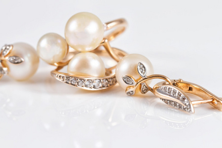 优雅的金戒指和金耳环与珍珠图片