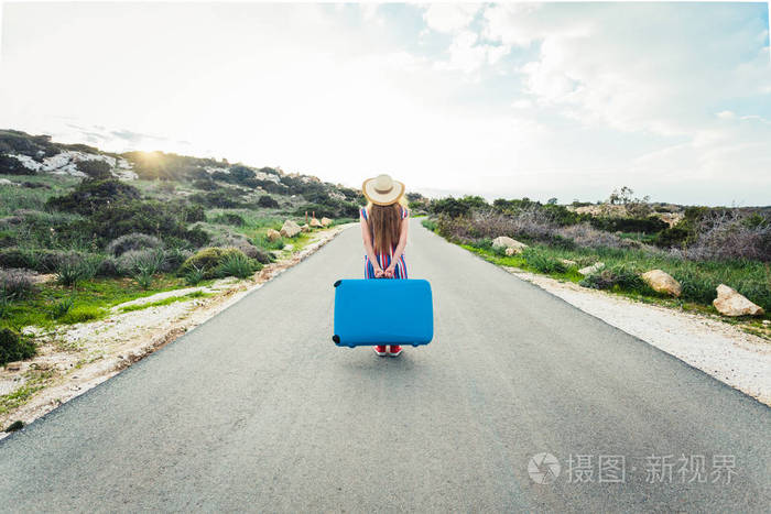 女人与蓝色的箱子路上的背影