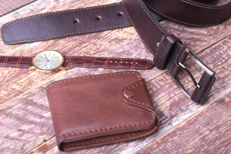 一套男装配件的业务与皮带, 钱包, 手表和吸烟管在一个木制的背景。时尚与旅游的概念