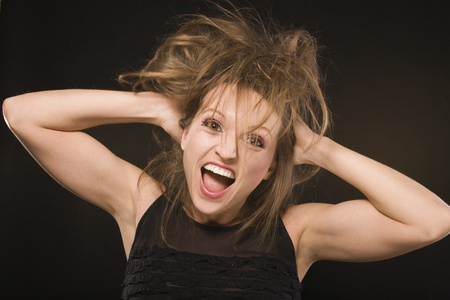 年轻的愚蠢的疯狂女孩,头发乱糟糟的,做着愚蠢的脸照片