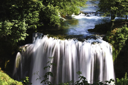 河 Slunjcica, 在它的嘴前面在 Korana, 形成急流和池塘在绿色中间, 在瀑布通过石灰华障碍肆虐