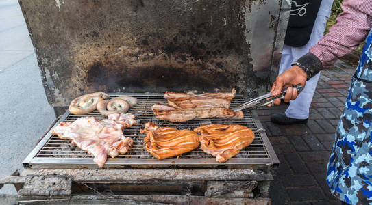 一个男人在木炭龟上烤猪肉肉, 乡村烧烤照片