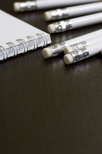 白色的弹簧垫和简单的铅笔, 用于笔记和草图。学校和教学文具。在黑暗背景下