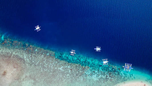 游客在美丽清澈的海水水落在奥斯洛布，菲律宾宿雾市附近的苏密隆碧海岛屿海滩游泳沙滩的鸟瞰图。增强颜色处理