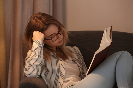 年轻帅哥在家读书,晚上看书冬天晚上在家里拿着一杯热饮料读书的女人